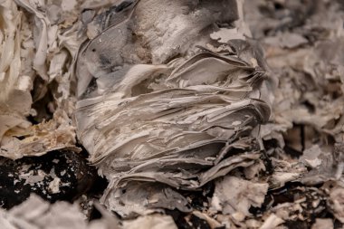 Yanmış kağıttan bir kül yığını, yakın plan, seçici odak.