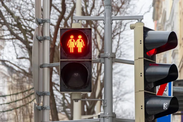 A red traffic light with the image of two female figures with hearts, standing hand in hand, European tolerance.
