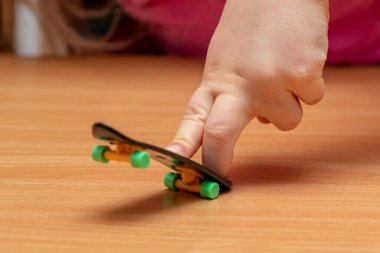 fingers on a fingerskeit on a wooden surface, close-up, selective focus.