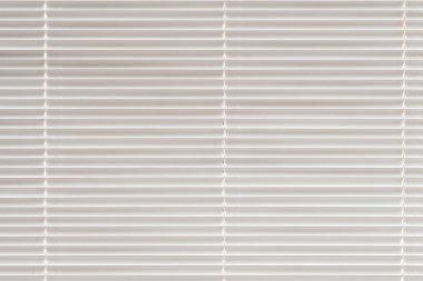 Closed blinds on the window, close-up, light tone.