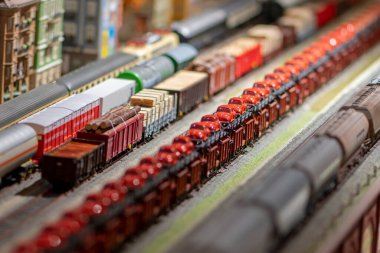 Demiryolu trenlerinin elektrikli modelleri oyuncak bir tren yolunda, tüm özelliklere sahip bir tren istasyonunda, seçici bir odak noktasında.