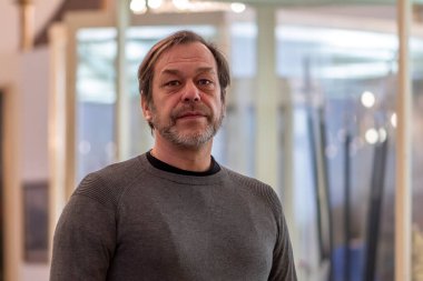 Portrait of an elderly happy man 45-50 years old on a blurry background in the room.