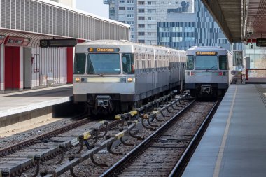 Metro vagonlarından gelen trenler, şehir binalarının arka planına karşı istasyondan geçer; Avusturya, Viyana, 20 Mart 2023.