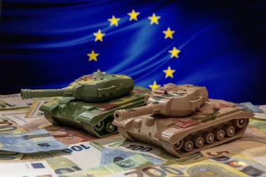 Tanklar, Avrupa Birliği bayrağının arka planına karşı avro banknotlarının üzerinde duruyorlar. Kavram: Ukrayna 'ya askeri ve mali yardım, Avrupa' da silah harcamaları, Batı 'nın Rusya ile savaşı, 