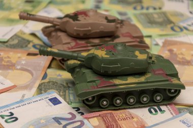 İki askeri tank, bir sürü Euro banknotları. Kavram: Ordu ve silahlara devlet bütçesi harcamaları, Ukrayna 'ya askeri yardım, teçhizat ve silah transferi.