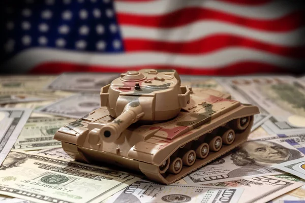 stock image A military tank on the background of the American flag, American dollar bills. Concept: military and financial assistance to Ukraine, high arms costs, arms supplies from America.