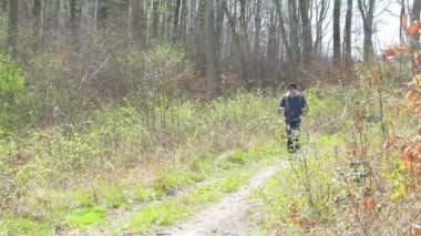 Sırt çantalı bir erkek turist, dağlık bir bölgede yürürken İskandinav bölgesine takılıyor. Kavram: sağlıklı yaşam tarzı, aktif eğlence.
