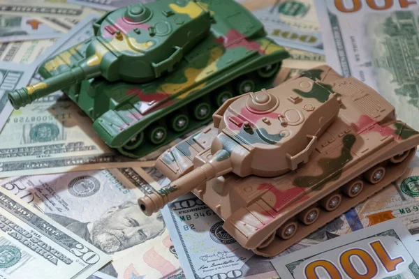 stock image Military tanks, American dollars, close-up.  Concept: arms spending, military aid, arms and ammunition trade, money loan, war in Ukraine.