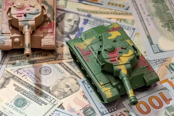 stock image Two military tanks, American dollars, close-up.  Concept: arms spending, military aid, trade in weapons and ammunition, money credit.