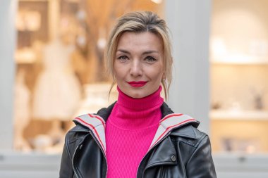 35-40 yaşlarındaki duygusal sarışın bir kadının portresi Avrupa şehrinin bulanık arka planında.