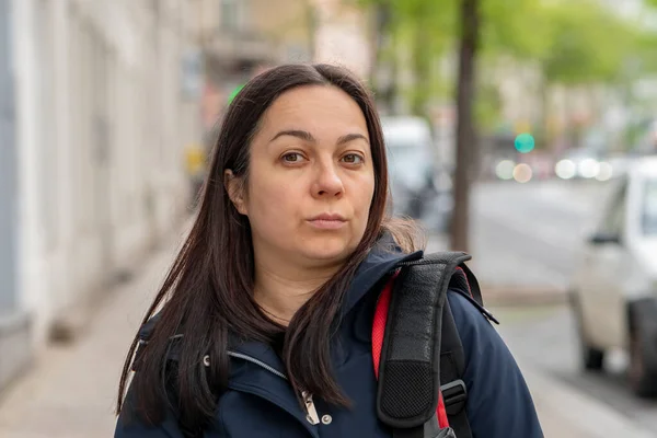 stock image Street portrait of a 40-45-year-old woman on a neutral blurred urban background.