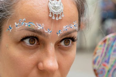 Aynaya bakan Hintli kadın, neşeli bir makyaj..