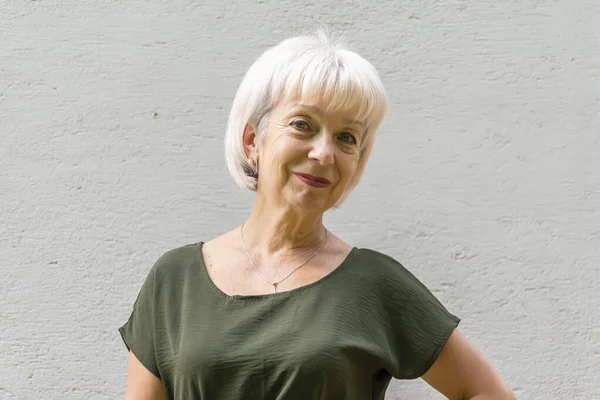 明るい背景に灰色の髪を持つ笑顔の高齢女性6065歳の肖像画 コンセプト モデル外観のスタイリッシュな年金受給者 アクティブライフ — ストック写真