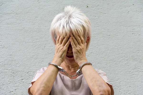 Elderly Woman Handcuffs Hides Her Face Gray Background Old Criminal — Stock Photo, Image