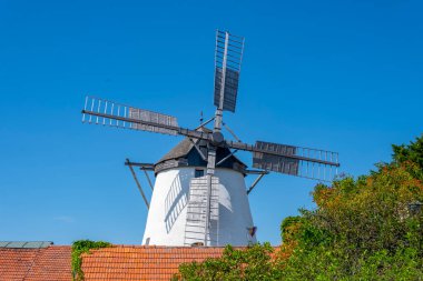 Avrupa 'nın eski yel değirmeni, kırsal alan, kiremitli çatı, mavi gökyüzü.