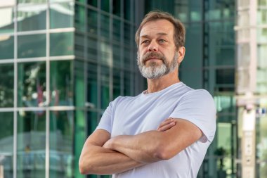 50-55 yaşlarında güçlü, kaslı, yaşlı bir adamın portresi.