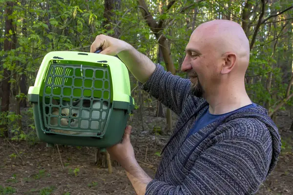 Man Examines Animal Cat Carrier Stock Image