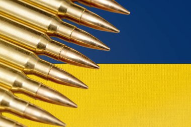Ukrayna bayrağında mühimmat ve mermi kovanları var. Kavram: Ukrayna 'da savaş, Avrupa' dan maddi destek, silah satışları, Ukrayna ordusunun silahlanması, mühimmat ticareti.
