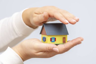 Bir kadının avucundaki küçük bir evin maketi. İkinci el üst tarafı koruyor..