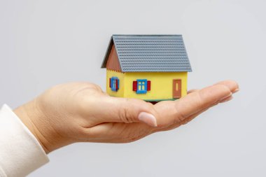 Bir kadının avucundaki küçük bir ev. 