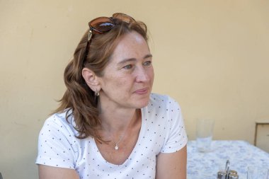 45-50 yaşlarındaki ciddi ve güzel bir kadının portresi. Yazın tarafsız bir arkaplanda..