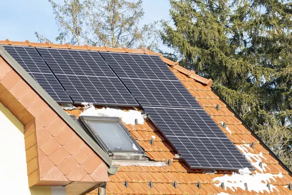 Cold weather, solar panels on the roof of a residential home. Continue to generate green energy for homeowners in winter.