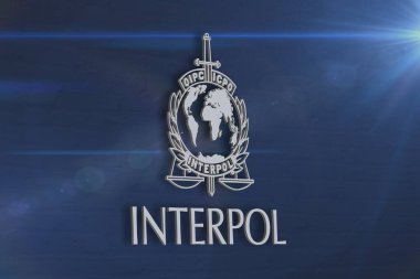 Interpol olarak bilinen Uluslararası Suç Polis Örgütü 'nün mavi dokulu arkaplan üzerindeki amblemi.