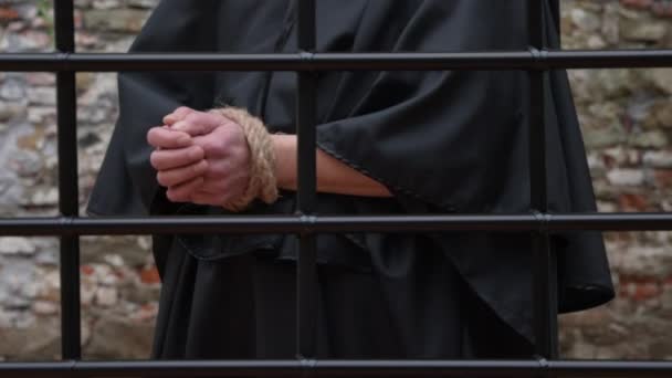 Călugăr Într Mantie Neagră Mâinile Legate Frânghie Spatele Unui Grătar — Videoclip de stoc