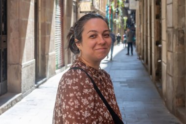 40-45 yaşlarında İspanyol bir kadının sokak portresi. Tarafsız bir arka plana karşı, kameraya bakıyor..