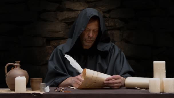 Old Monk Writes Quill Pen Scroll Parchment Sitting Table Stone — Video