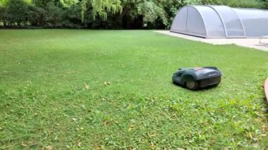 Robot çim biçme makinesi otomatikman bahçedeki çimleri biçer, çimleri biçer.