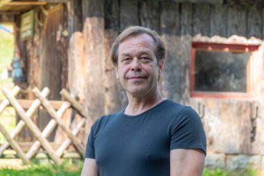 50-55 yaşlarındaki yaşlı bir adamın portresi, güçlü yapılı, tarımsal yapıların tarafsız bir geçmişine karşı..