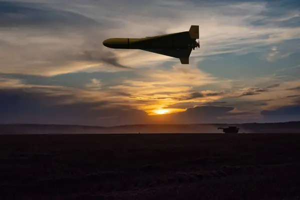 Bir Rus askeri dronu huzurlu bir tarlanın üzerinde uçuyor, akşam aydınlatması.