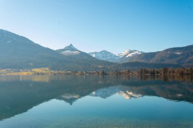 Huzurlu Wolfgangsee Gölü kristal berrak suyuyla görkemli dağları yansıtır..