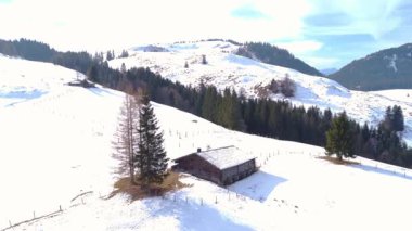 Kış sessizliğinin ortasında dağ kulübeleri: karla kaplı yamaçlarda kaybolan küçük ahşap binalar