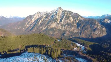 Ağaç gölgeleri ve kar tarlaları olan dağlardan oluşan bir gökyüzü..