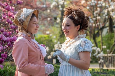 Tarihi canlandırma: 19. yüzyıl kadınları çiçek açan ağaçlar arasında sohbetin keyfini çıkarıyorlar