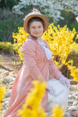 Kadınlık ve tarih tek bir resimde: Orta yaşlı bir kadının klasik kıyafeti, bahar manzarası, şefkat