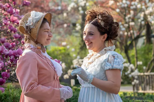 Tarihi canlandırma: 19. yüzyıl kadınları çiçek açan ağaçlar arasında sohbetin keyfini çıkarıyorlar