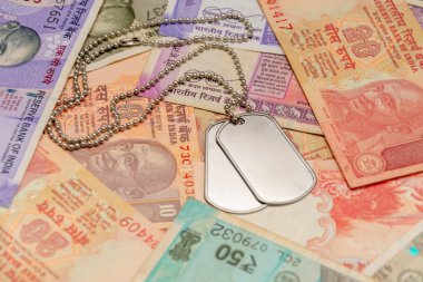 Hindistan banknotlarının arka planında askeri simgeler var. Hindistan 'da askerliğin vatanseverlik, hizmet ve finansal yönlerinin bir sembolü.