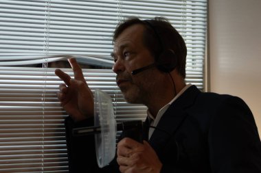 Keşif ve kulak misafiri olmak. Bir adam pencerenin yanında parabolik bir mikrofon tutuyor ve her sesi dinliyor.