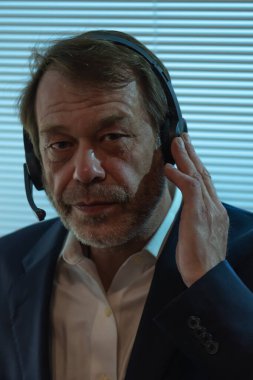 Profesyonel Gözetleme. Mikrofon kulaklıklı adam dinlemeye odaklanmış.