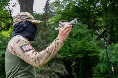 Bir askeri operatör taktik görev için insansız hava aracı ve uydu iletişimi kullanır.