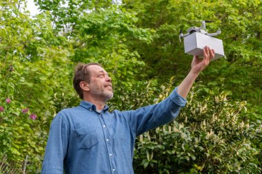 Gelecekteki konsept: Yaşlı bir adam uçmaya hazır bir kurye İHA 'sını gösteriyor