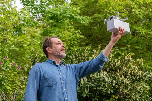Gelecekteki konsept: Yaşlı bir adam uçmaya hazır bir kurye İHA 'sını gösteriyor