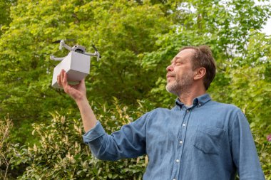 Kendine güvenen bir adamın portresi fırlatma için bir kutu drone hazırlıyor.