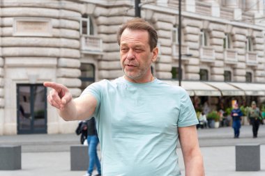 Şehirdeki duygusal iletişimi. Bir adam parmağını gösterir, belki yönü açıklar ya da umumi alanda duygularını ifade eder.