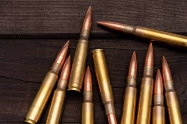 Kaba ahşap bir tahtanın üzerinde duran çeşitli kalibreli mühimmat. Avlanma, vurma veya askeri meselelerle ilgili konular için uygun