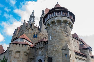 Mavi gökyüzünün altında kuleleri ve siperleri olan bir ortaçağ taş kalesi.