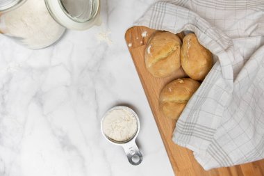 Mutfak masasının tepesinde taze pişmiş ekmekli çörekler.